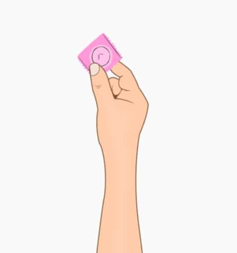 Person holding a condom, one method of barrier contraception